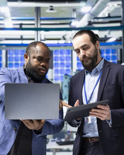 Multiethnic professional consultants engaging in a strategy meeting briefing on the production line, aligning corporate goals with renewable power engineering innovations. Photovoltaics.